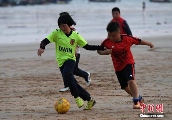 资料图：球员正在沙滩上踢比赛。<a target='_blank'  data-cke-saved-href='http://www.chinanews.com/' href='http://www.chinanews.com/'>中新社</a>记者 王东明 摄