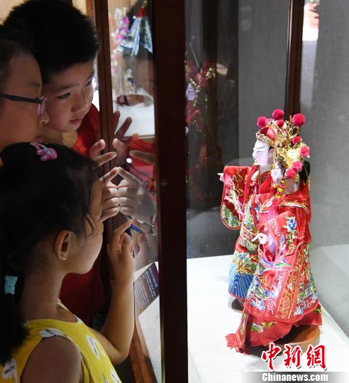 参展木偶头木雕作品《状元·夫人》吸引观展孩子们目光。　记者刘可耕 摄