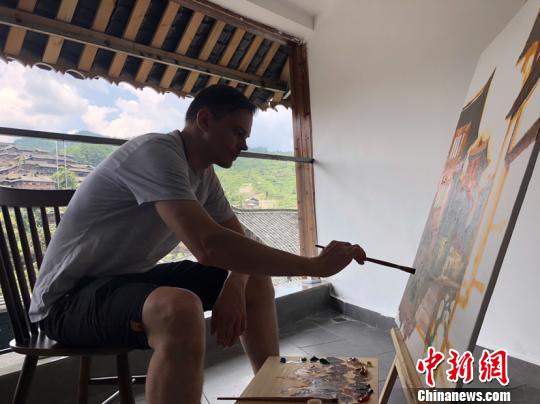 图为俄罗斯油画家在贵州西江千户苗寨里创作。刘威 摄