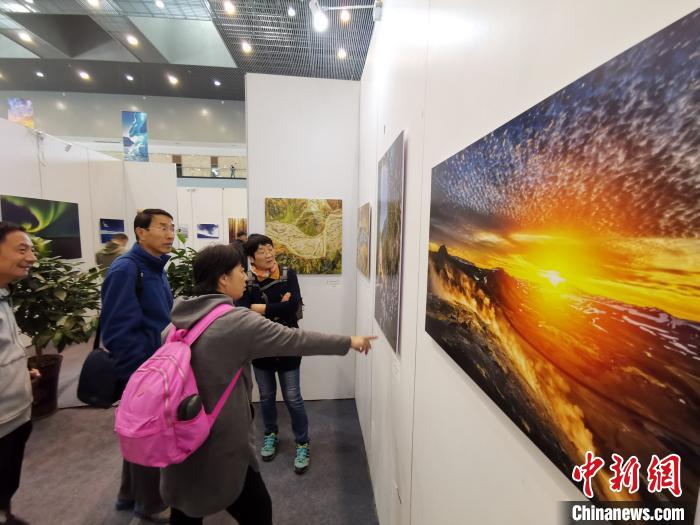 众多摄影工作者、爱好者在摄影周上欣赏摄影作品。　刘畅 摄