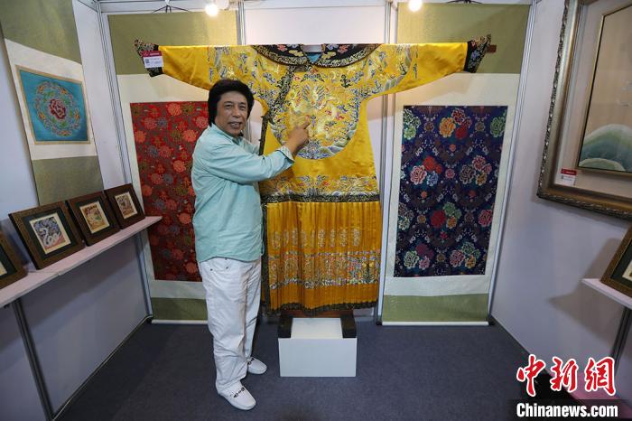 中国工艺美术大师金文向观众介绍他利用云锦工艺一比一复制的清代龙袍。　泱波 摄