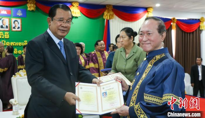 中国侨网图为洪森首相向柬埔寨著名侨领方侨生颁授荣誉博士学位证书。当地媒体提供