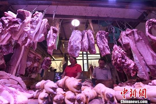 资料图：重庆主城区的一家农贸市场内，商贩正在摆放猪肉。<a target='_blank'  data-cke-saved-href='http://www.chinanews.com/' href='http://www.chinanews.com/'>中新社</a>记者 陈超 摄