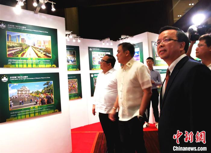 新任中国驻菲大使黄溪连(右一)与菲律宾总统府新闻部副部长马尔文(左三)、乔治(左二)共同参观16日揭幕的《庆祝澳门回归20周年》图片展。关向东 摄