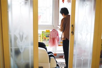 12月23日，天津滨海新区，好友要给张英2岁的女儿买新衣服，汤玉娥拍照给好友看现有的衣服样式。