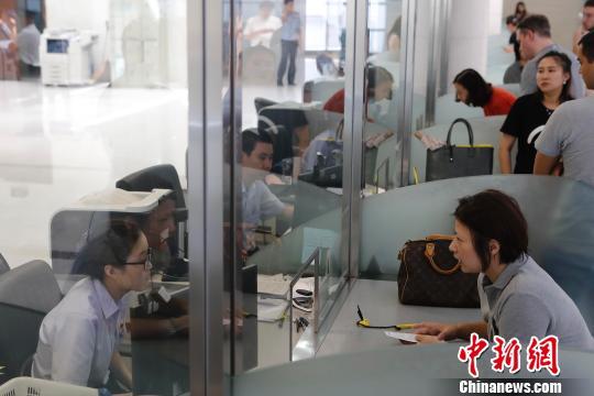 资料图：上海市公安局出入境管理局内，民众正在咨询和办理相关业务。　殷立勤 摄