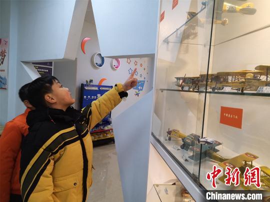 杨腾祥制作飞机模型，吸引学生参观。　林馨　摄