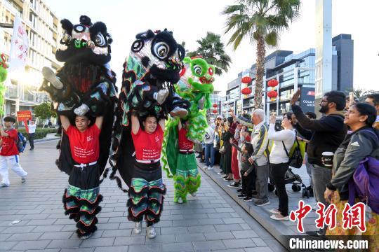 中国大学生体育协会舞龙舞狮分会的大学生们挥舞着狮子与市民互动。　杨华峰 摄