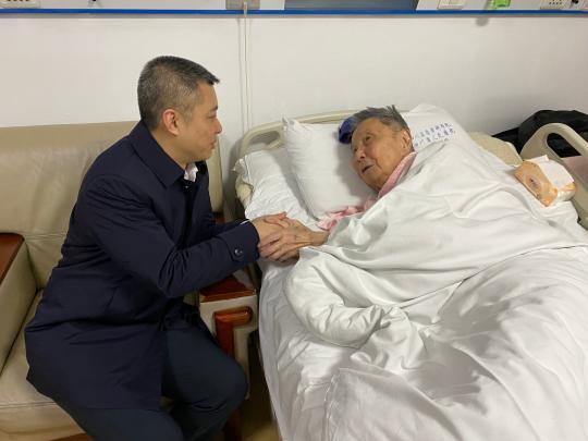 中国侨网文甦在医院看望慰问百岁老归侨邱林。（钟欣摄）　钟欣　摄