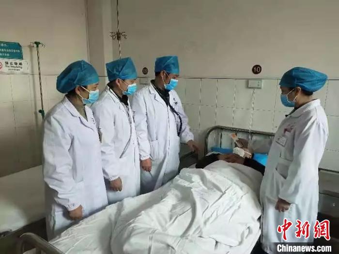 湖南省政协委员、衡阳市中医医院院长王诚喜(左三)在病房查看患者情况。湖南省政协供图