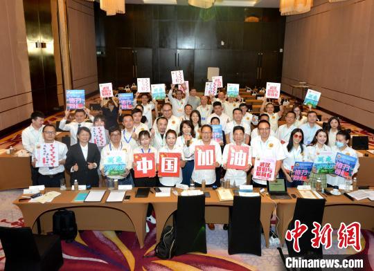 中国侨网联合大会上，会员们高举“中国加油”等标语表达对中国抗击疫情的支持。　陈悦　摄