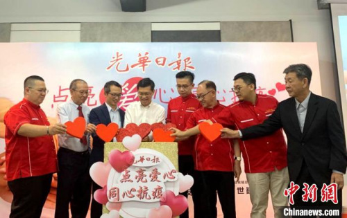 马来西亚《光华日报》为支持中国抗击疫情举办的“点亮爱心，同心抗疫”义卖会。图为开幕仪式上，大家一同把“爱心”投进爱心箱。　陈悦 摄