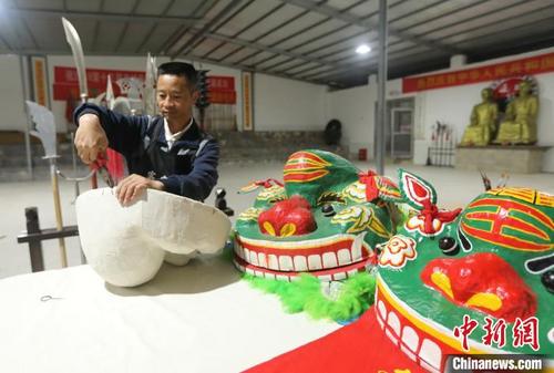 中国侨网青狮制作传承人黄林忙着制作青狮头。　黄水林　摄