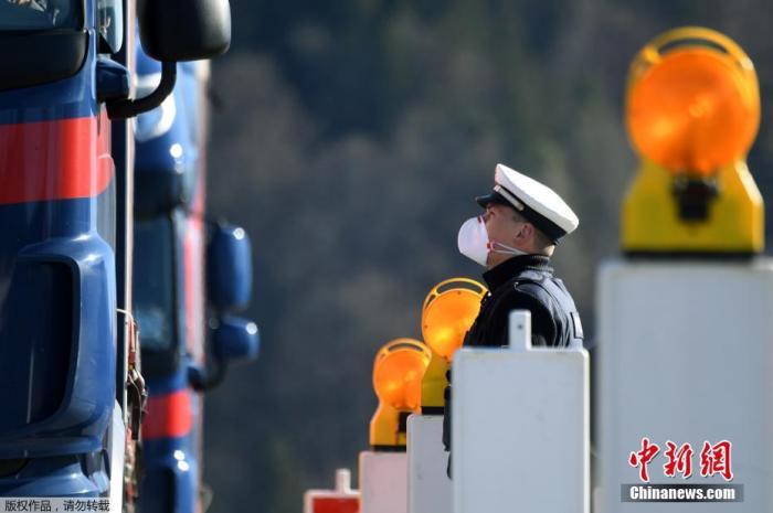 当地时间3月16日，在德国与奥地利之间的过境点，一名德国警察正在询问过境的卡车司机。当日，德国对周边五个国家的边境实施了管制。