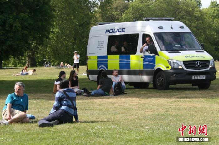 当地时间5月17日，英国迎来了“有条件解封”后的首个周日，在伦敦，不少市民在户外享受休闲时光，警察驾驶警车在公园中四处巡查，劝告民众“保持两米社交距离”。
<a target='_blank'  data-cke-saved-href='http://www.chinanews.com/' href='http://www.chinanews.com/'>中新社</a>记者 张平 摄