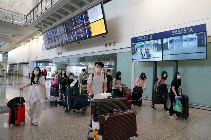 3月18日，众多乘客搭乘英国伦敦飞香港的航班抵达香港国际机场，其中不乏香港和内地赴英留学生。（图片来源：中新社）