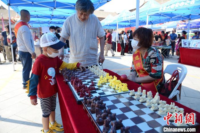 6月12日，小朋友试玩蒙古象棋。　刘文华 摄