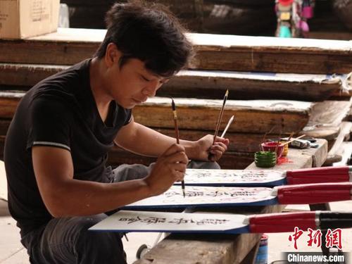 中国侨网俞建良正在绘制船桨。受访者本人供图