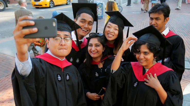 哈佛大学毕业生拍照。（图片来源：路透社）