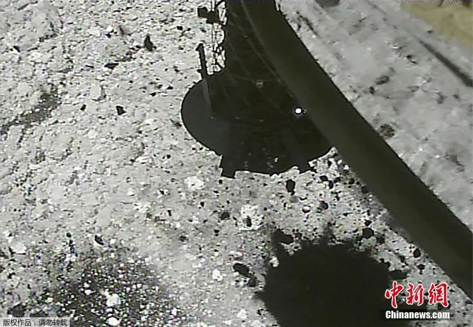 资料图：2019年3月，日本宇宙航空研究开发机构公布隼鸟2号探测器着陆小行星“龙宫”和采集样品的画面。图为隼鸟2号探测器向“龙宫”表面发射子弹，以搜集小行星岩石和沙尘。
