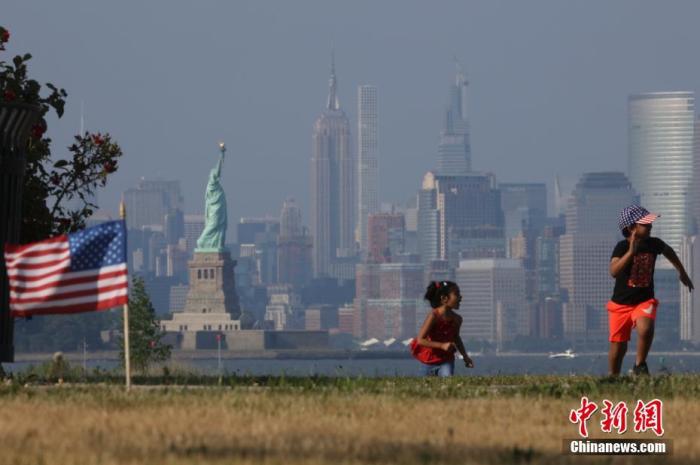 资料图：当地时间7月4日，两名孩童在纽约曼哈顿对岸的海滨草坪上奔跑。
<a target='_blank'  data-cke-saved-href='http://www.chinanews.com/' href='http://www.chinanews.com/'>中新社</a>记者 廖攀 摄