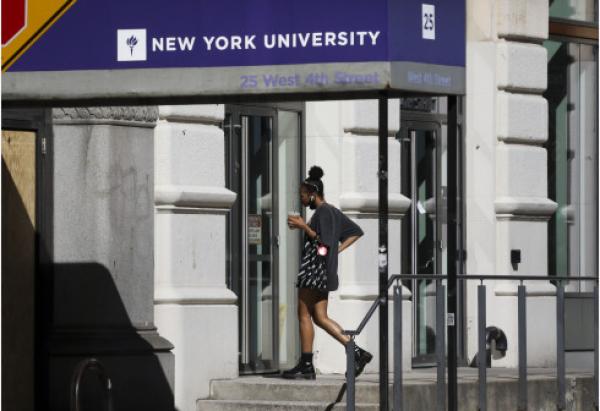 一名女子查看美国纽约大学教学楼入口处张贴的通知。新华社 图