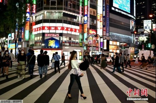 资料图：5月15日，日本解除紧急事态宣言，人们穿过东京新宿区的一条街道。（<a target='_blank' href='http://www.chinanews.com/' >中新网</a>）