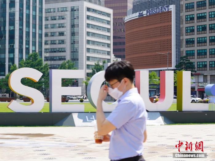 6月23日，一位韩国首尔市民经过首尔广场。近来，包括韩国首尔、仁川、京畿道在内的首都圈确诊病例持续增加。 中新社记者 曾鼐 图