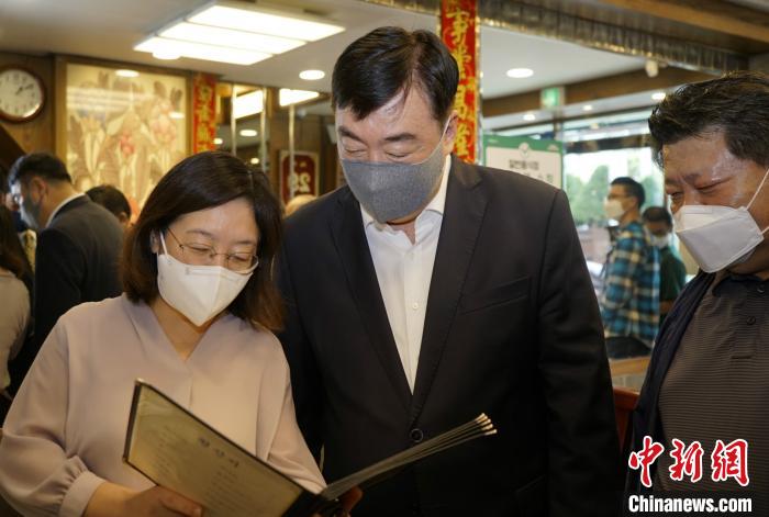 中国驻韩国大使邢海明(中)29日走访华侨商户，向侨胞致以节日问候。　曾鼐 摄