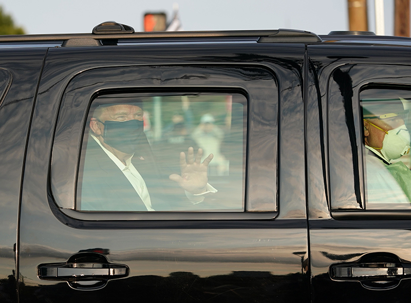 当地时间2020年10月4日，美国马里兰州，美国总统特朗普在车中戴着口罩朝支持者挥手。 人民视觉 图