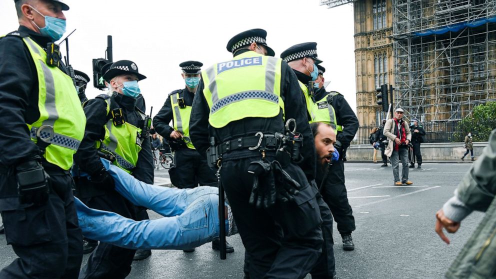 Police detain a man, during a coronavirus anti-lockdown protest on Westminster Bridge, in London, Saturday, Oct. 24, 2020. (AP Photo/Alberto Pezzali)