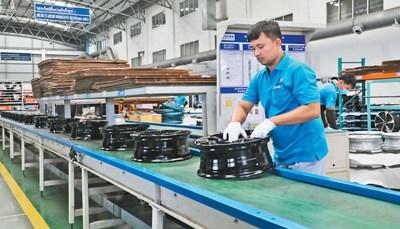 中国侨网新泰车轮公司的泰籍员工在车轮生产线上工作。本报记者 孙广勇摄