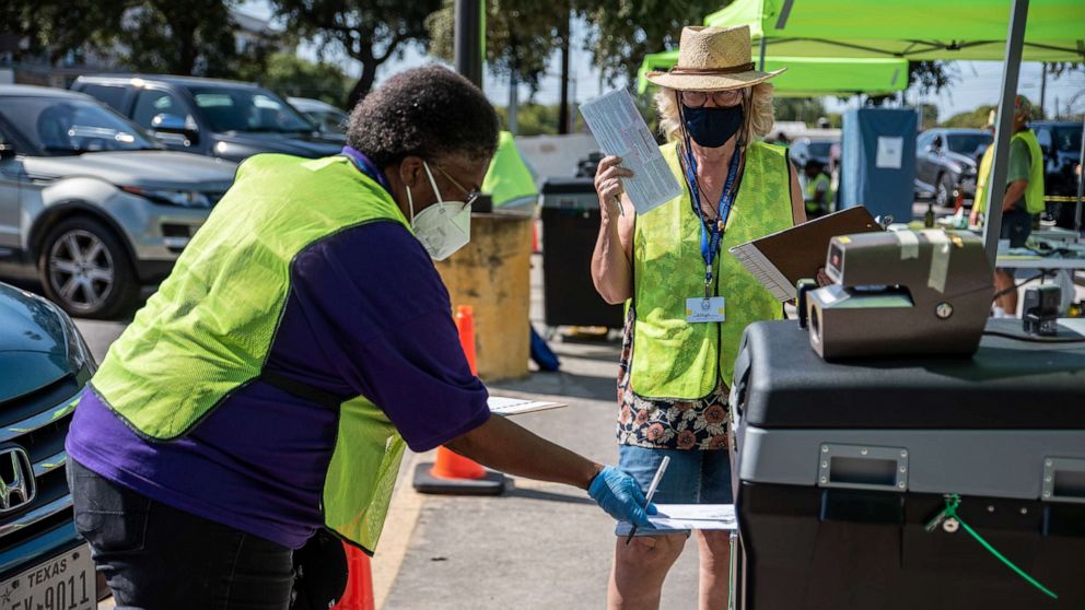 PHOTO: Workers drop voters ballots into a secure box at a ballot drop off location on Oct. 13, 2020, in Austin, Texas.