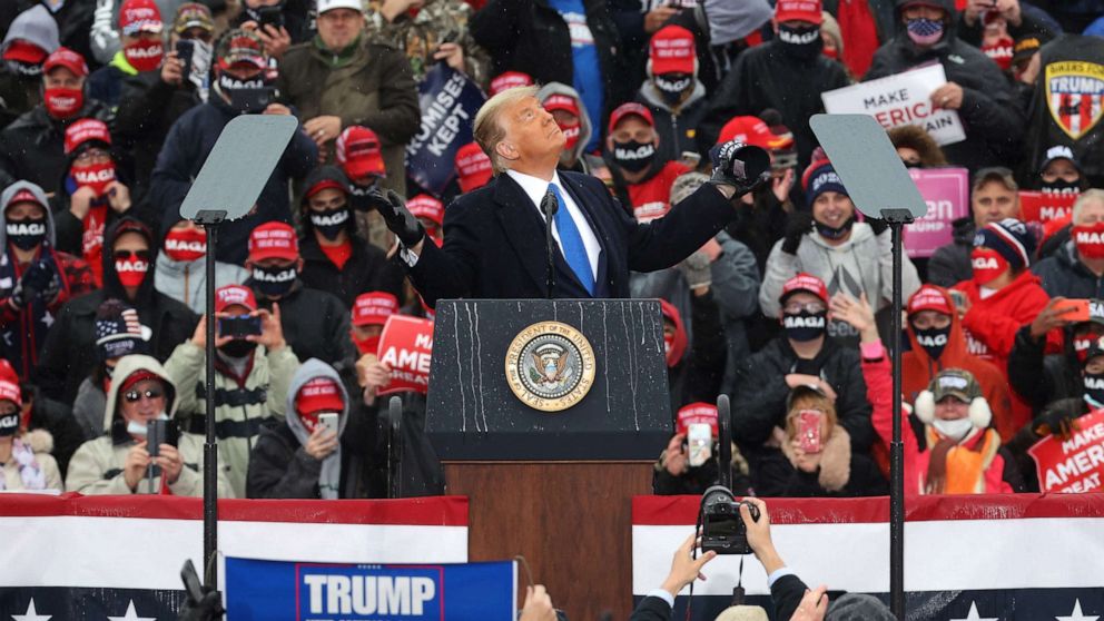 PHOTO: President Donald Trump looks up at the rain as he addresses thousands of supporters during a campaign rally at Capital Region International Airport Oct. 27, 2020, in Lansing, Mich.