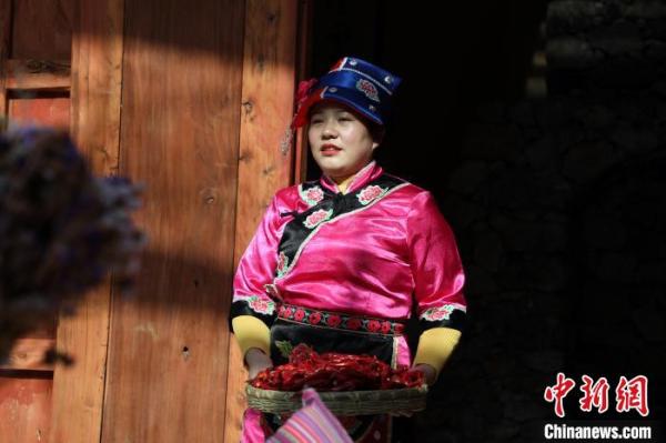 图为当地村民着藏族服饰在民宿酒店打工。　魏建军 摄