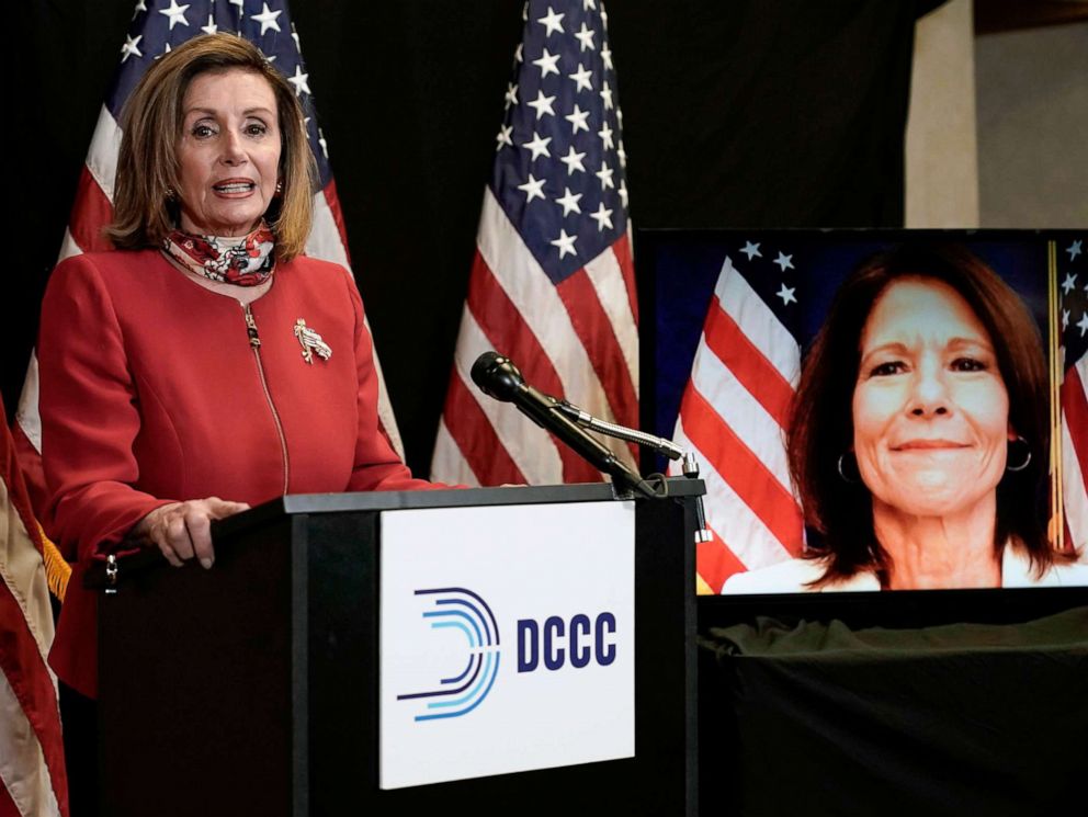PHOTO: Speaker of the House Nancy Pelosi talks to reporters along with Rep. Cheri Bustos, who appears on screen, Nov. 3, 2020, at the Democratic National Committee headquarters in Washington, D.C.