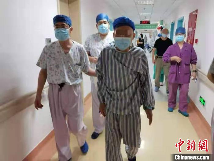 手术后，章先生在医护人员的陪同下，自己走回病房。上海岳阳医院供图