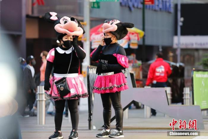 当地时间11月9日，美国纽约市时代广场装扮卡通形象的人，佩戴着口罩。