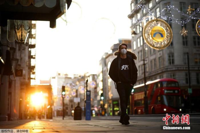 图二 资料图：当地时间11月5日，英国伦敦，市民戴口罩上街。从5日凌晨开始，英国进入第二次全国性封锁限制阶段。
