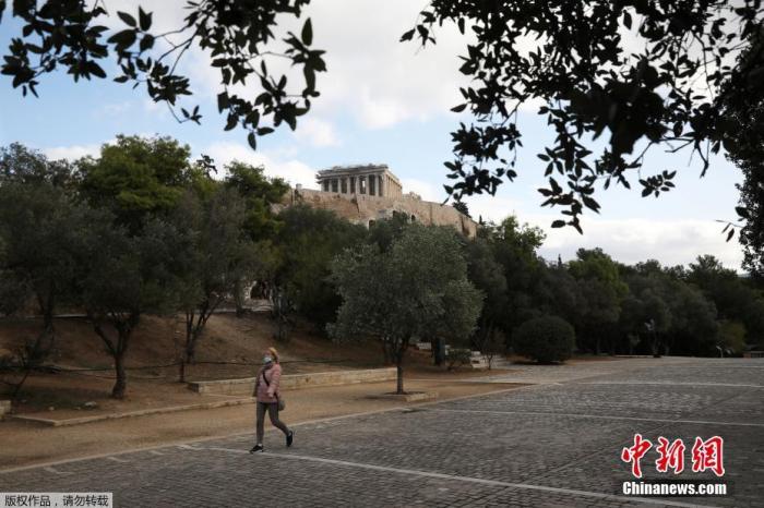 当地时间11月7日，希腊雅典，一名戴口罩女子经过帕特农神庙。为遏制新冠疫情，自当地时间7日早晨6时起，希腊全国进入为期三周的封锁状态。希腊政府发言人佩萨斯指出：“目前，我们并不排除延长封锁的可能性。”