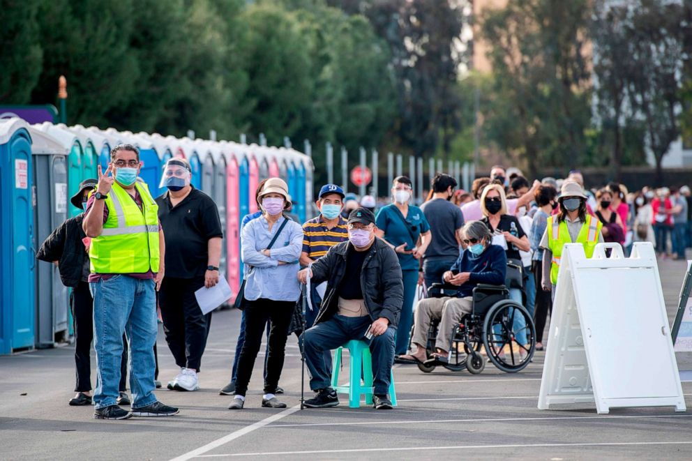 PHOTO: People wait in line in a Disneyland parking lot to receive Covid-19 vaccines on the opening day of the Disneyland Covid-19 vaccination 