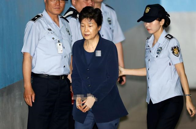 资料图：朴槿惠戴手铐出庭受审。