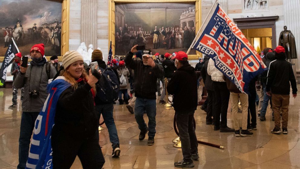 PHOTO: Jenny Cudd, in the hat and Trump flag cape, stands in the US Capitol's Rotunda along with other protesters on Jan. 6, 2021, in Washington, DC.