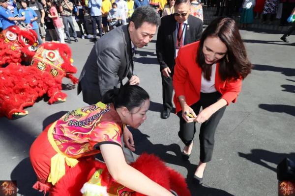 新西兰总理阿德恩着一身喜庆红装为醒狮点睛。