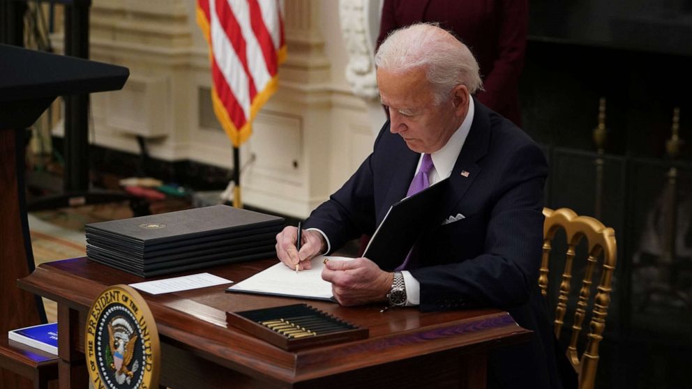 PHOTO: President Joe Biden signs an executive order promoting safe travel as part of the Covid-19 response in the State Dining Room of the White House in Washington, D.C., Jan. 21, 2021.