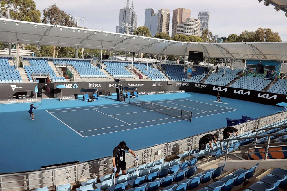 PHOTO: Workers disinfect the seats on court 3 during a warm up session at the Melbourne Park in Melbourne on Feb. 4, 2021.