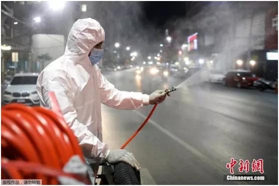 当地时间2021年1月4日，泰国曼谷，一名工作人员上街喷洒消毒剂。