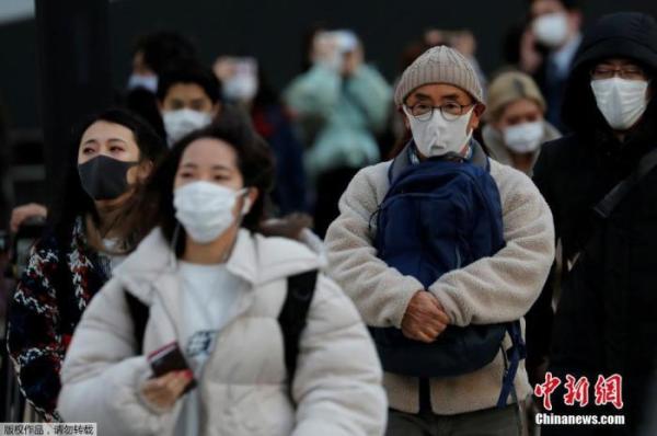 资料图：当地时间1月7日，日本东京，民众佩戴口罩上街。