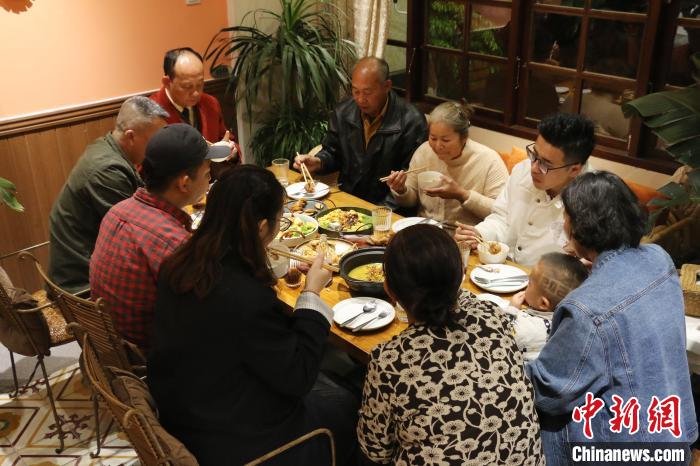 一家人围坐在一起品尝洪春梅烹制的团圆大餐。　柯宁 摄