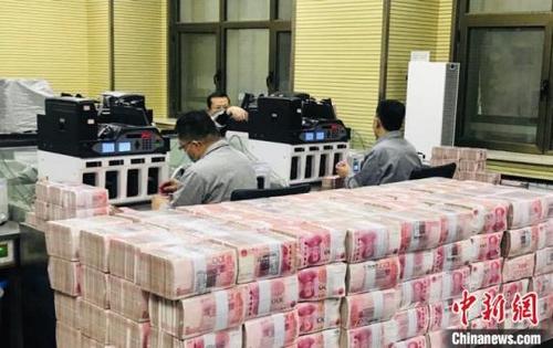 中国侨网甘肃一银行的点钞员在清点人民币。(资料图)　艾庆龙　摄